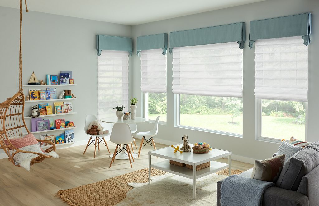 Soft Roman shades and light blue colors make t his playroom calming and gentle