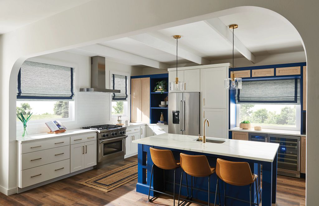 an open and well lit kitchen has a decorative arch that adds softness and mixes roman shades with textured fabric and dark blue accents