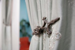 white drapery fabric with close up of bronze decorative