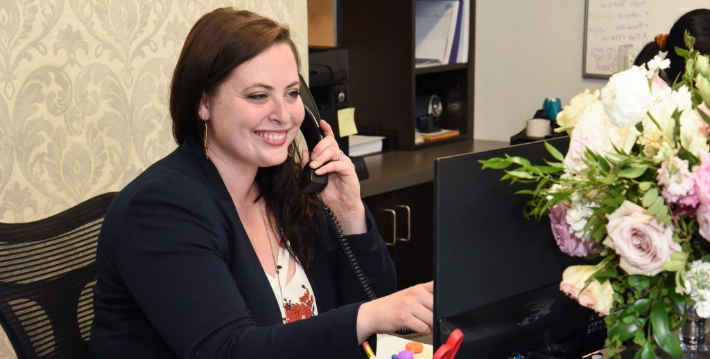 customer service representative at a window covering company smiling while on the phone