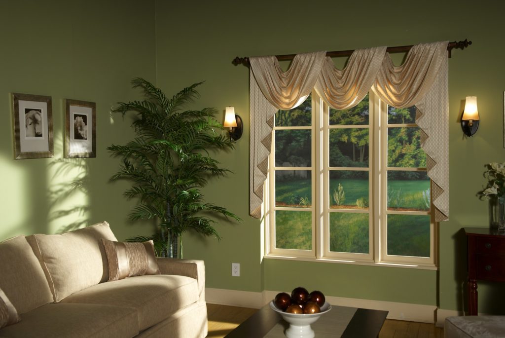 sage green walls and a window with shiny off-white decorative swag