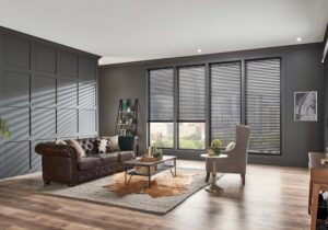 Living room with dark green walls, hardwood floors, and dark shades