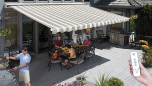 Grey and white striped retractable awning covering a family eating at an outdoor table