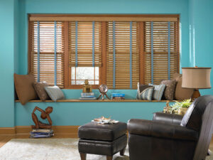 Wood blinds in a living room with blue walls and a lounge chair