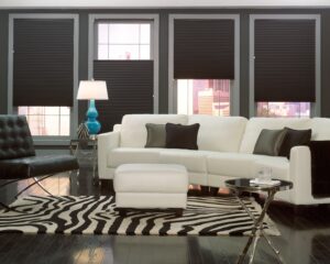 Living room with dark shades at varying heights of each window
