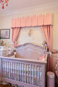 Picture of a pink custom valance above a crib.