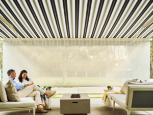 People sitting on a patio under a retractable awning with retractable protective front screen