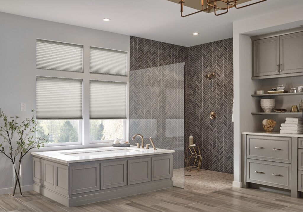 bathroom with 4 windows above the large tub covered with cellular shades